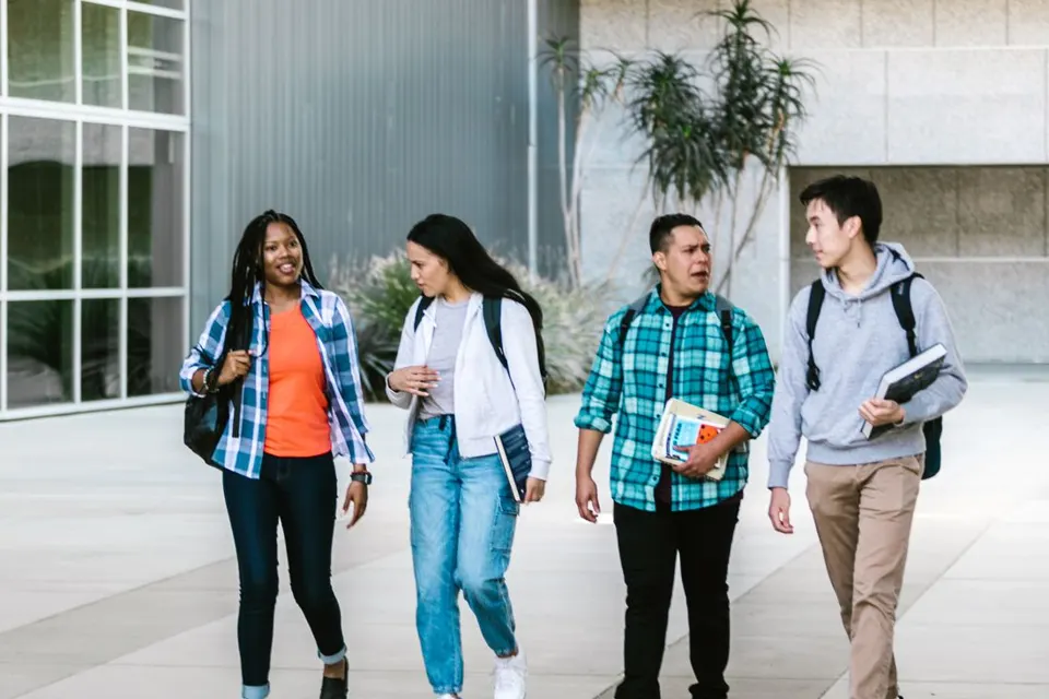 A diverse group of students walking across campus together
