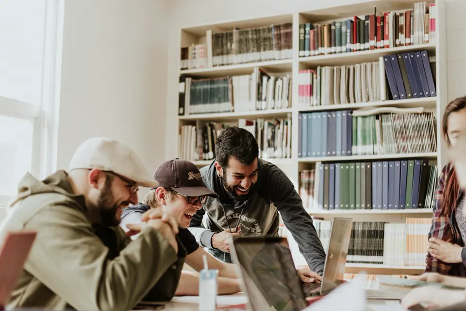 A diverse group of university students working together on laptops